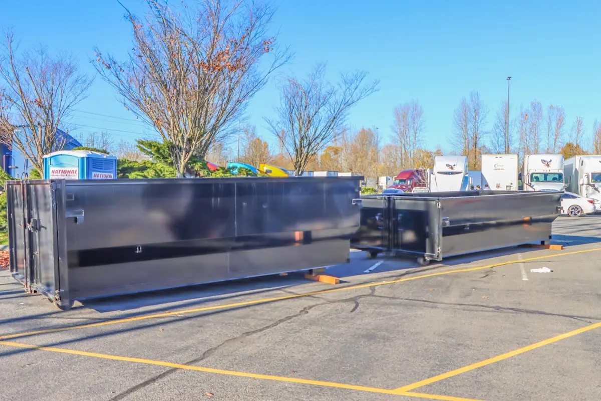 Professional dumpster rental service with roll-off container on residential driveway in Grandville